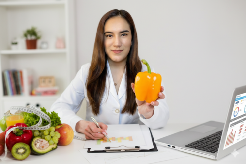 Nutrióloga Jocelyn sosteniendo un pimiento en una consulta nutricional
